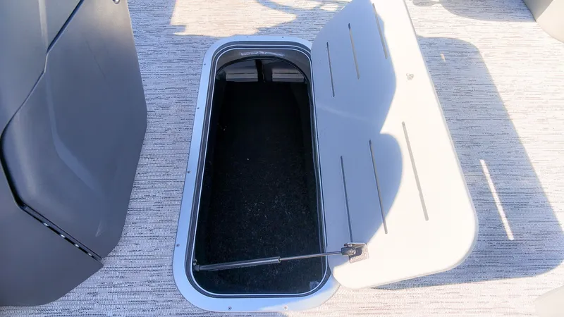 Slide: The Image of An open storage hatch on a boat with carpeted flooring and gray surfaces. - 12