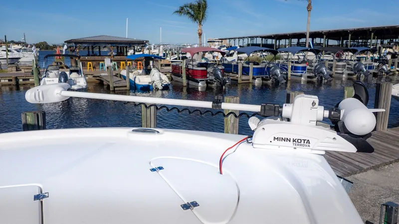 Slide: The Image of Tidewater 2210 Carolina Bay 2026 at dock with Minn Kota trolling motor. - 2