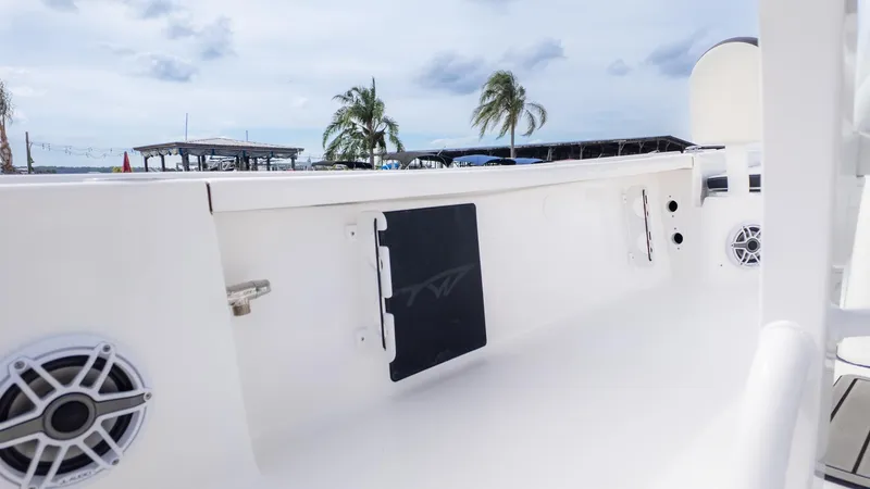 Slide: The Image of The image shows the deck of a Tidewater 2210 Carolina Bay boat with speakers and palm trees in the background. - 6