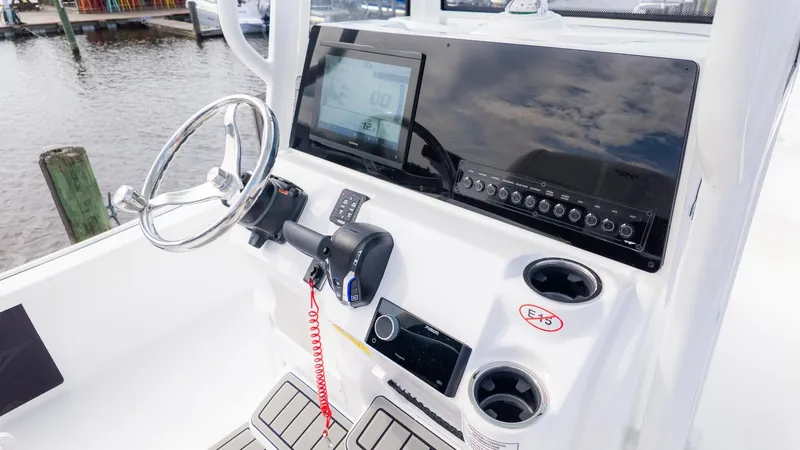 Slide: The Image of The image shows the helm of a Tidewater 2210 Carolina Bay boat. It is situated by the water. - 11