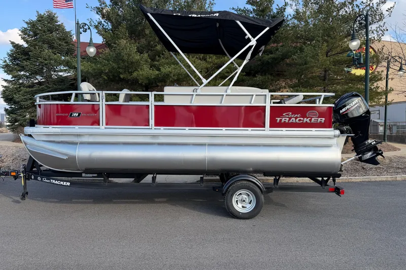 The Image of 2026 Sun Tracker Bass Buggy 18 DLX pontoon boat on trailer, parked outdoors. - 0