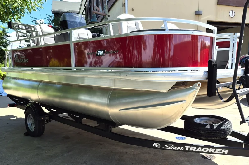 Slide: The Image of 2026 Sun Tracker Bass Buggy 18 DLX pontoon boat on trailer, red and silver design. - 3