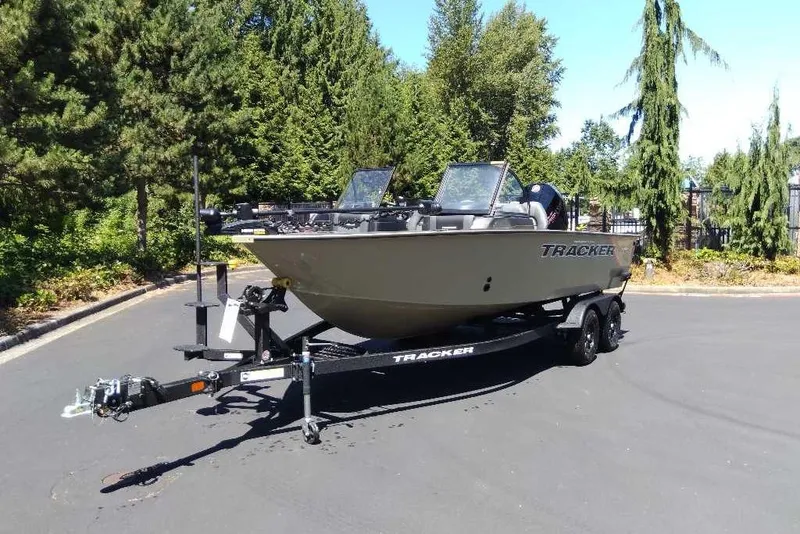 Slide: The Image of 2026 Tracker Targa V-18 Combo boat on trailer, parked outdoors with trees in background. - 73