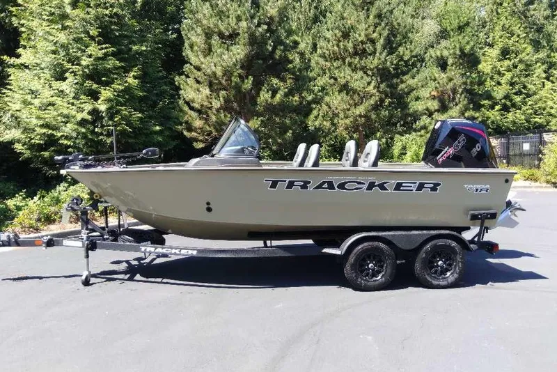 The Image of 2026 Tracker Targa V-18 Combo boat on trailer, parked outdoors with trees in background. - 0