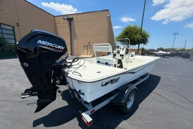 Slide: The Image of 2026 Mako Pro Skiff 17 CC boat with Mercury engine on trailer, parked outdoors. - 3