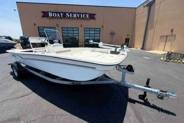 Slide: The Image of 2026 Mako Pro Skiff 17 CC boat on trailer outside service center. - 2