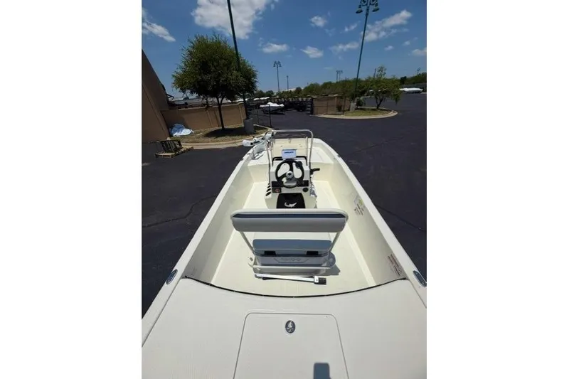 Slide: The Image of 2026 Mako Pro Skiff 17 CC boat, interior view, parked outdoors under a clear sky. - 7