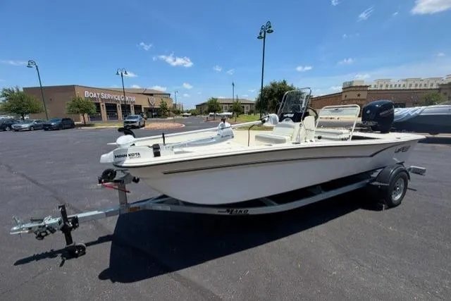 Slide: The Image of 2026 Mako Pro Skiff 17 CC boat on trailer in parking lot, sunny day. - 1