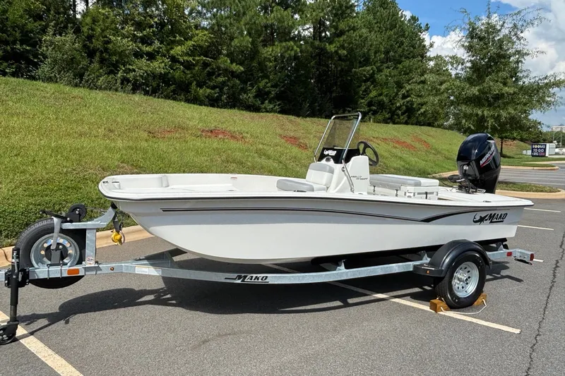 Slide: The Image of 2026 Mako Pro Skiff 15 CC boat on trailer, parked outdoors. - 1