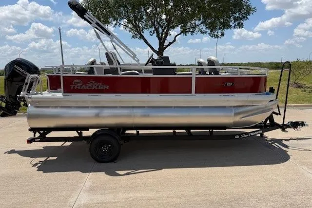 The Image of 2026 Sun Tracker Bass Buggy 18 DLX pontoon boat on trailer, parked outdoors. - 1