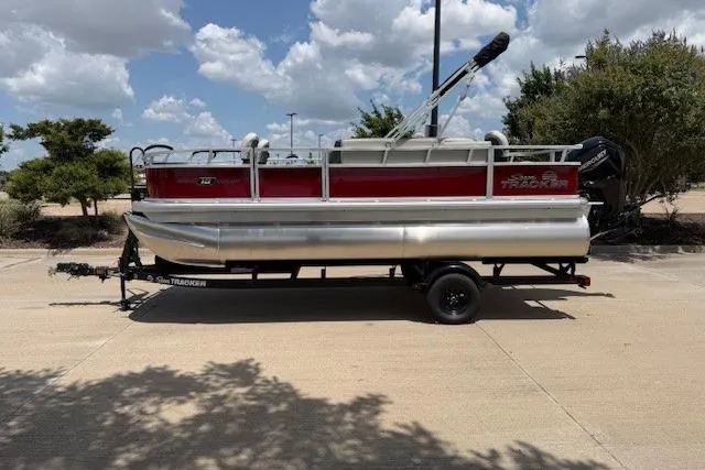 Slide: The Image of 2026 Sun Tracker Bass Buggy 18 DLX pontoon boat on trailer, parked outdoors. - 8