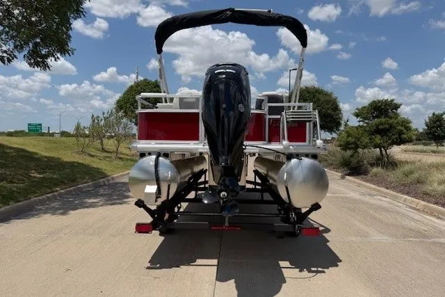 Slide: The Image of 2026 Sun Tracker Bass Buggy 18 DLX pontoon boat on trailer, rear view, outdoors. - 5
