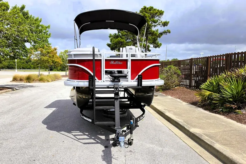 Slide: The Image of 2026 Sun Tracker SportFish 20 DLX pontoon boat on trailer, parked outdoors. - 6