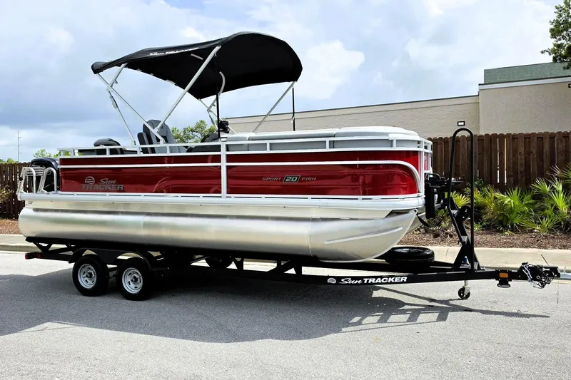Slide: The Image of 2026 Sun Tracker SportFish 20 DLX pontoon boat on trailer, red and silver design. - 4