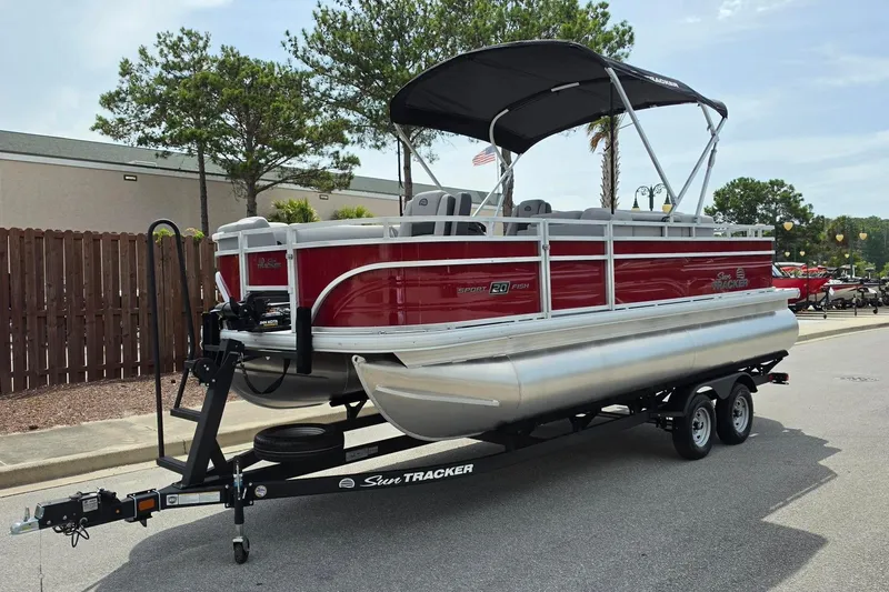 Slide: The Image of 2026 Sun Tracker SportFish 20 DLX pontoon boat on trailer, parked outdoors. - 9
