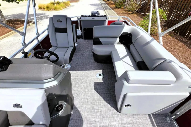 Slide: The Image of 2026 Sun Tracker SportFish 20 DLX pontoon boat interior with gray seating and steering console. - 16