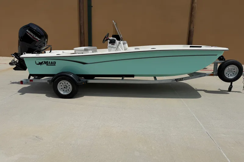 Slide: The Image of 2026 Mako Pro Skiff 17 CC boat on trailer, featuring a sleek design and Mercury engine. - 1