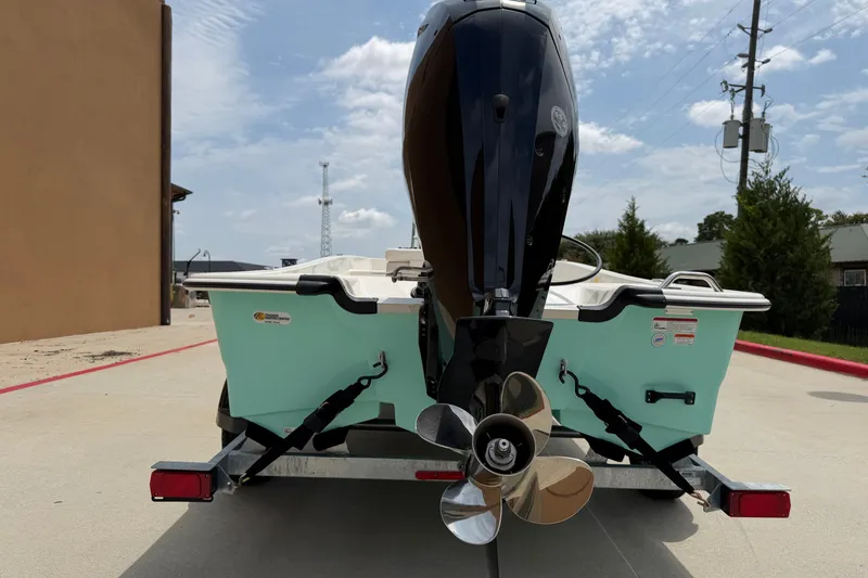 Slide: The Image of 2026 Mako Pro Skiff 17 CC boat rear view with outboard motor on trailer. - 6