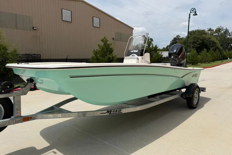 Slide: The Image of 2026 Mako Pro Skiff 17 CC boat on trailer, parked outdoors. - 2