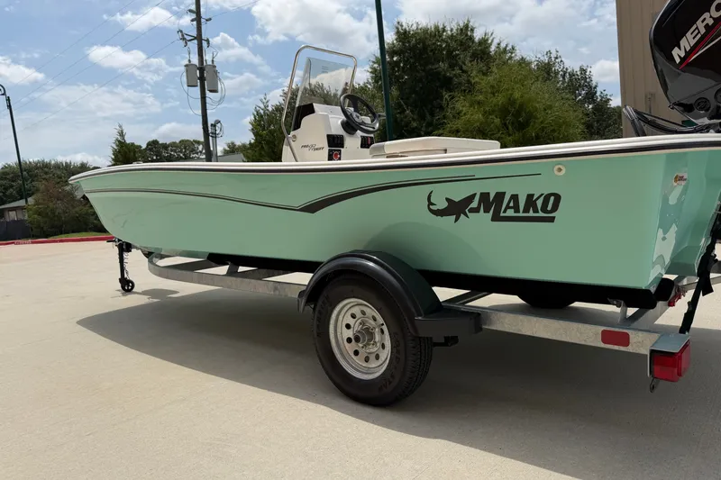 Slide: The Image of 2026 Mako Pro Skiff 17 CC boat on trailer, mint green hull, outdoor setting. - 4