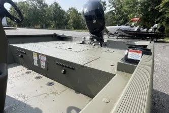 Slide: The Image of 2026 Tracker Grizzly 2072 CC boat with outboard motor, parked outdoors. - 8
