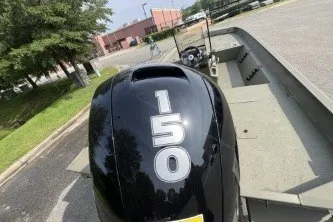 Slide: The Image of 2026 Tracker Grizzly 2072 CC boat with a 150 HP engine in a parking area. - 5