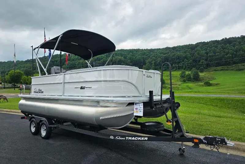 The Image of 2026 Sun Tracker Party Barge 20 DLX pontoon boat on trailer, scenic background. - 0
