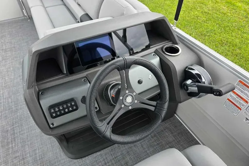 Slide: The Image of 2026 Sun Tracker Party Barge 20 DLX helm with steering wheel and control panel. - 5