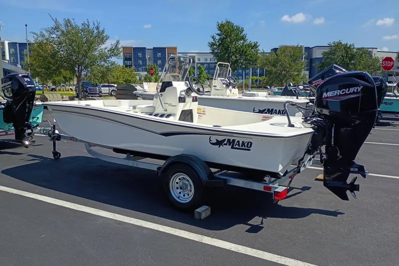 Slide: The Image of 2026 Mako Pro Skiff 15 CC boat with Mercury engine on trailer in parking lot. - 2