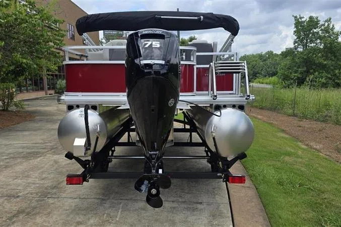 Slide: The Image of 2026 Sun Tracker Bass Buggy 18 DLX pontoon boat with Mercury 75 engine, parked outdoors. - 4