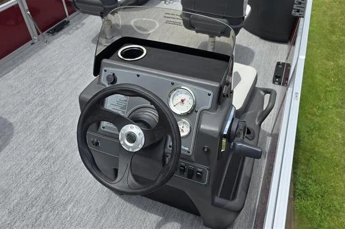 Slide: The Image of 2026 Sun Tracker Bass Buggy 18 DLX steering console with gauges and cup holder. - 7