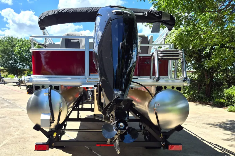 Slide: The Image of 2026 Sun Tracker Bass Buggy 18 DLX pontoon boat with outboard motor, parked outdoors. - 6
