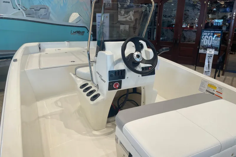 Slide: The Image of 2026 Mako Pro Skiff 17 CC boat interior with steering console and seating. - 2