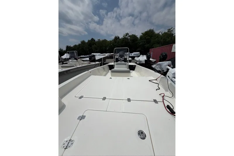 Slide: The Image of 2026 Mako Pro Skiff 17 CC boat with open deck and console, under cloudy sky. - 46