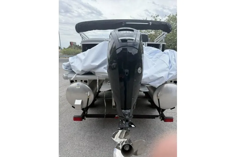 Slide: The Image of 2026 Sun Tracker Party Barge 20 DLX with covered outboard motor, rear view. - 4