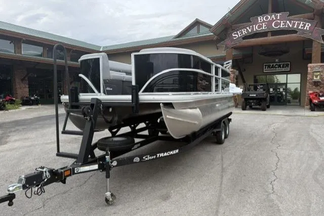 Slide: The Image of 2026 Sun Tracker Party Barge 20 DLX on trailer at boat service center. - 3