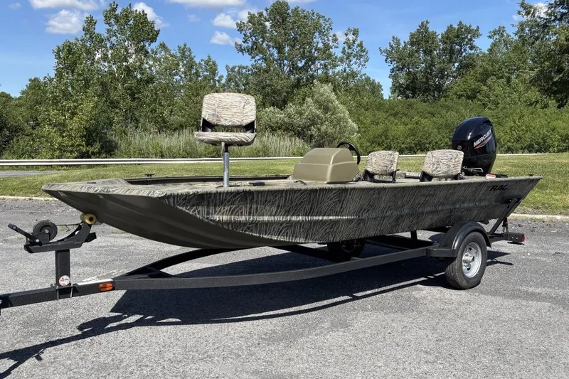 Slide: The Image of 2026 Tracker Grizzly 1754 SC boat on trailer, camo design, parked outdoors. - 3