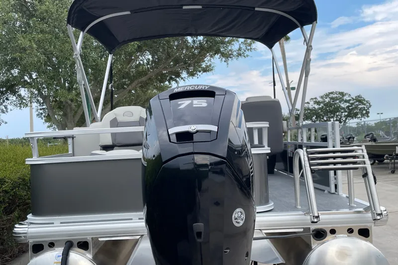 Slide: The Image of 2026 Sun Tracker Bass Buggy 18 DLX pontoon boat with Mercury 75 engine, docked outdoors. - 104