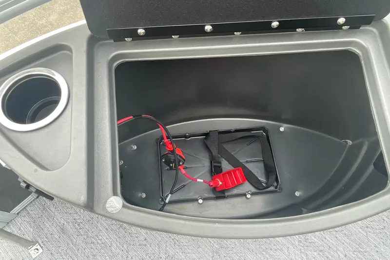Slide: The Image of Storage compartment of 2026 Sun Tracker Bass Buggy 18 DLX with cup holder and battery strap. - 23