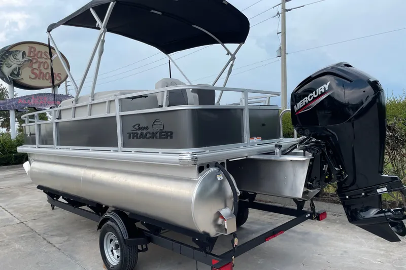Slide: The Image of 2026 Sun Tracker Bass Buggy 18 DLX pontoon boat with Mercury engine at Bass Pro Shops. - 2