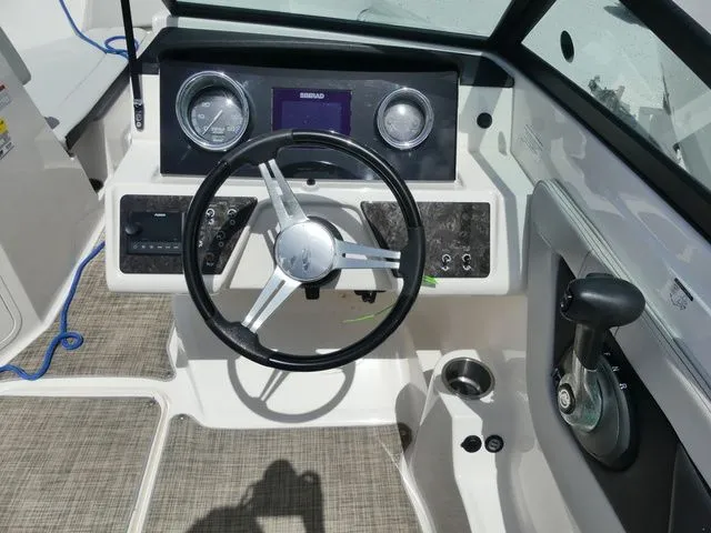 Slide: The Image of The cockpit of the 2021 Sea Ray SPX 190 Outboard features a modern steering wheel and dashboard. - 8