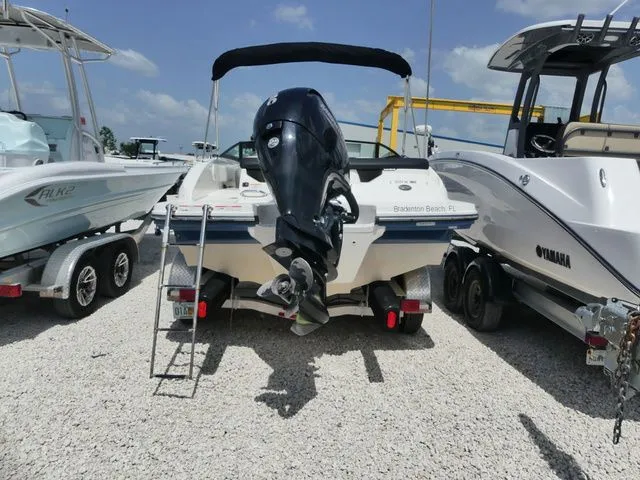 Slide: The Image of A 2021 Sea Ray SPX 190 Outboard is parked on gravel between other boats. - 4