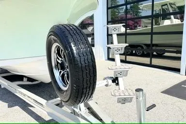 Slide: The Image of 2024 Sea Hunt Ultra 239 SE boat trailer with spare tire in showroom. - 6