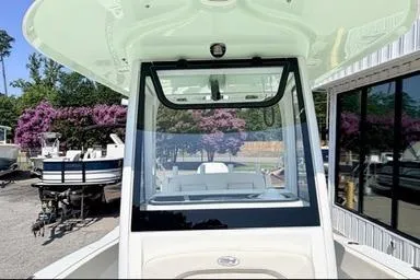Slide: The Image of 2024 Sea Hunt Ultra 239 SE boat with sleek design, docked near blooming trees. - 14