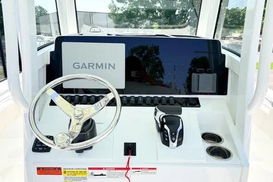 Slide: The Image of 2024 Sea Hunt Ultra 239 SE boat dashboard with Garmin display and steering wheel. - 18