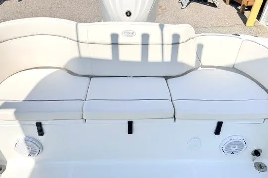 Slide: The Image of 2024 Sea Hunt Ultra 239 SE boat with white cushioned seating and built-in speakers. - 15