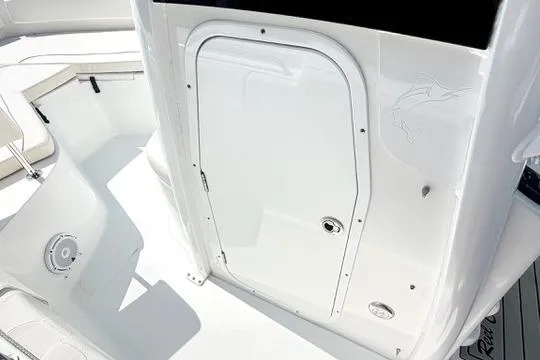 Slide: The Image of 2024 Sea Hunt Ultra 239 SE boat interior with white seating and storage compartment. - 28