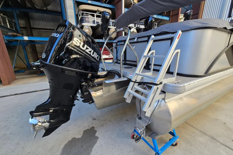 Slide: The Image of 2024 Godfrey Sweetwater 2486 SB pontoon boat with Suzuki outboard motor and boarding ladder. - 7