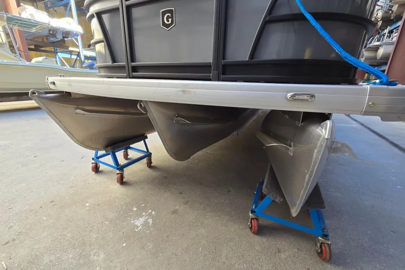 Slide: The Image of 2024 Godfrey Sweetwater 2486 SB pontoon boat on stands in a storage area. - 16