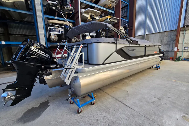 Slide: The Image of 2024 Godfrey Sweetwater 2486 SB pontoon boat with Suzuki outboard motor in storage facility. - 3